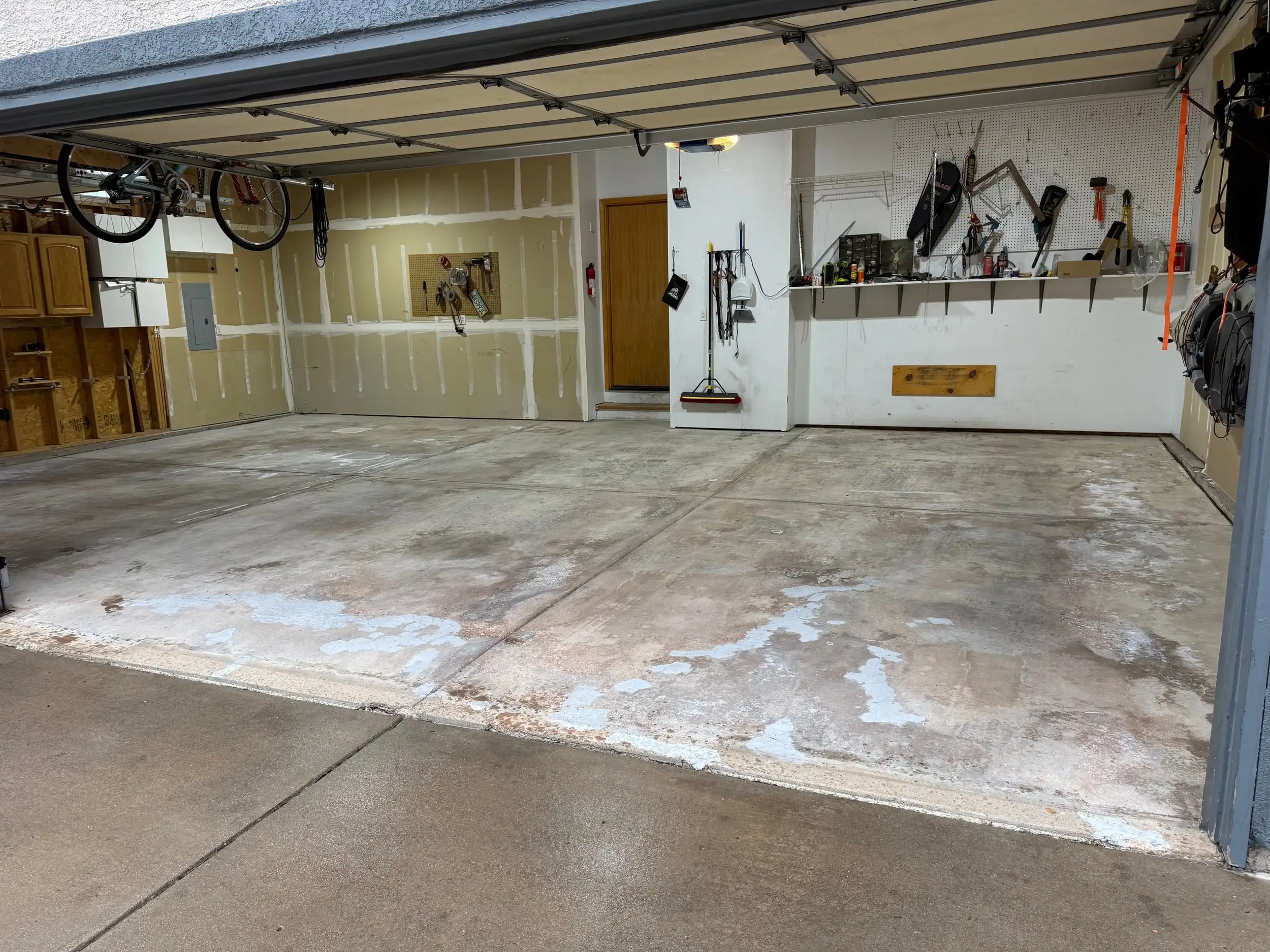 Two-car garage with stained, worn bare concrete before Epoxy Flake